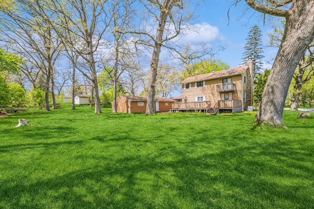 view of yard featuring an outdoor structure and a wooden deck