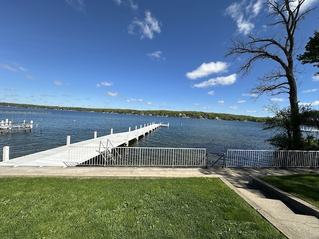 dock area with a lawn and a water view