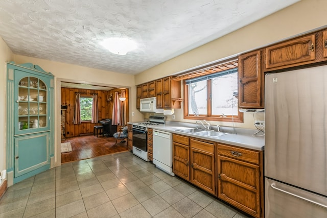 kitchen with sink, white appliances, and light tile floors