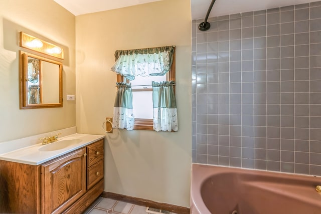 bathroom with tile flooring, tiled shower / bath, and vanity with extensive cabinet space