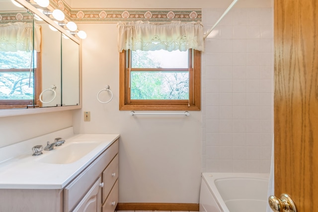 bathroom with tiled shower / bath and vanity