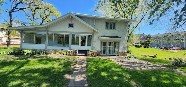 back of property featuring a yard and a sunroom