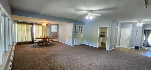 interior space featuring ceiling fan, a baseboard radiator, and dark carpet