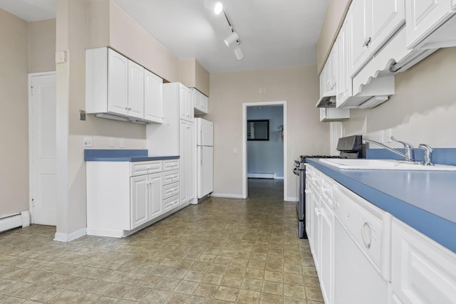 kitchen featuring white appliances, track lighting, baseboard heating, white cabinets, and sink