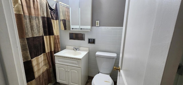 bathroom with tile walls, toilet, curtained shower, and vanity