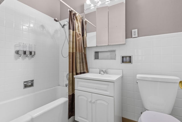 full bathroom featuring toilet, vanity, tile walls, and shower / bathtub combination with curtain