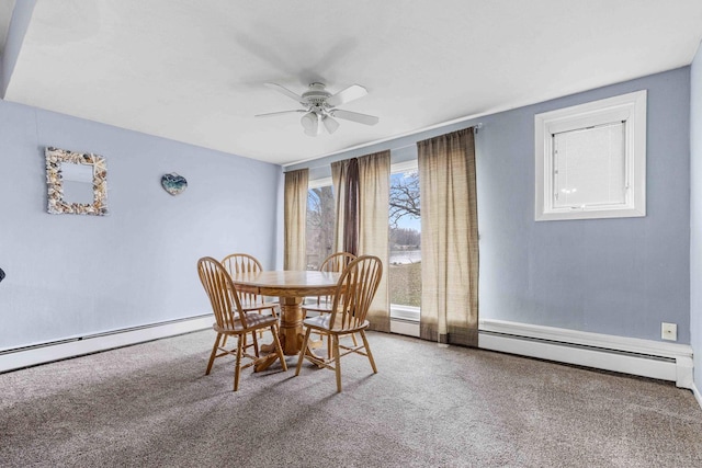 carpeted dining area with baseboard heating, ceiling fan, and a wealth of natural light