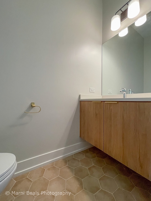 bathroom with vanity, toilet, and tile flooring