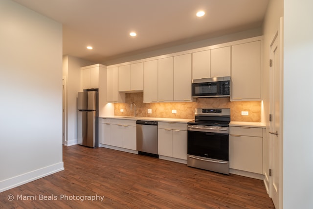 kitchen with dark hardwood / wood-style flooring, backsplash, and stainless steel appliances