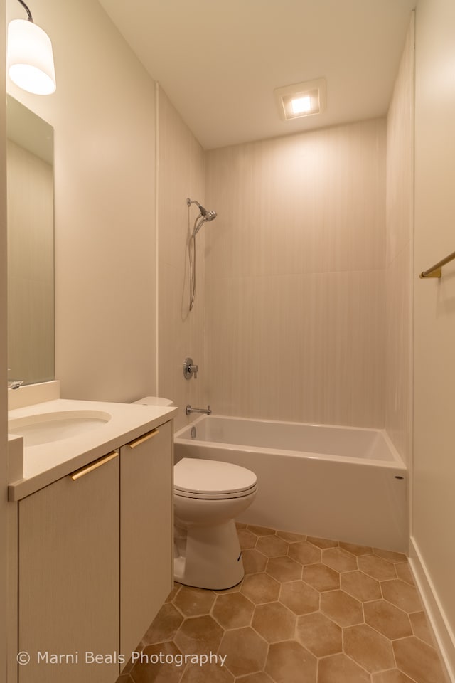 full bathroom featuring tile floors, tiled shower / bath, vanity, and toilet