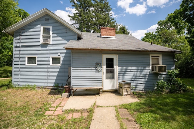 back of house featuring a chimney and a yard