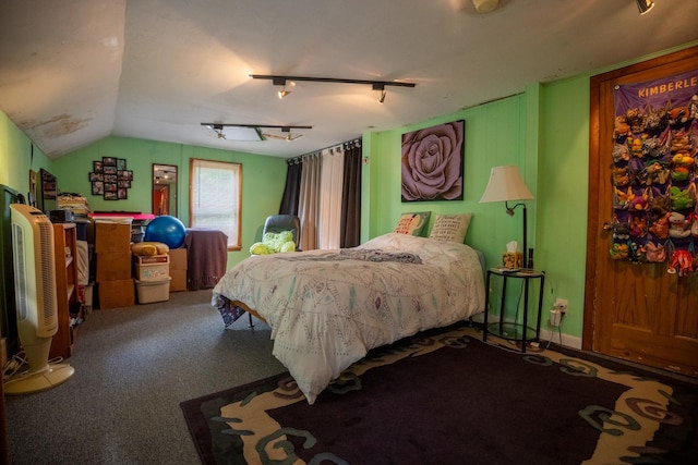 carpeted bedroom with rail lighting and vaulted ceiling