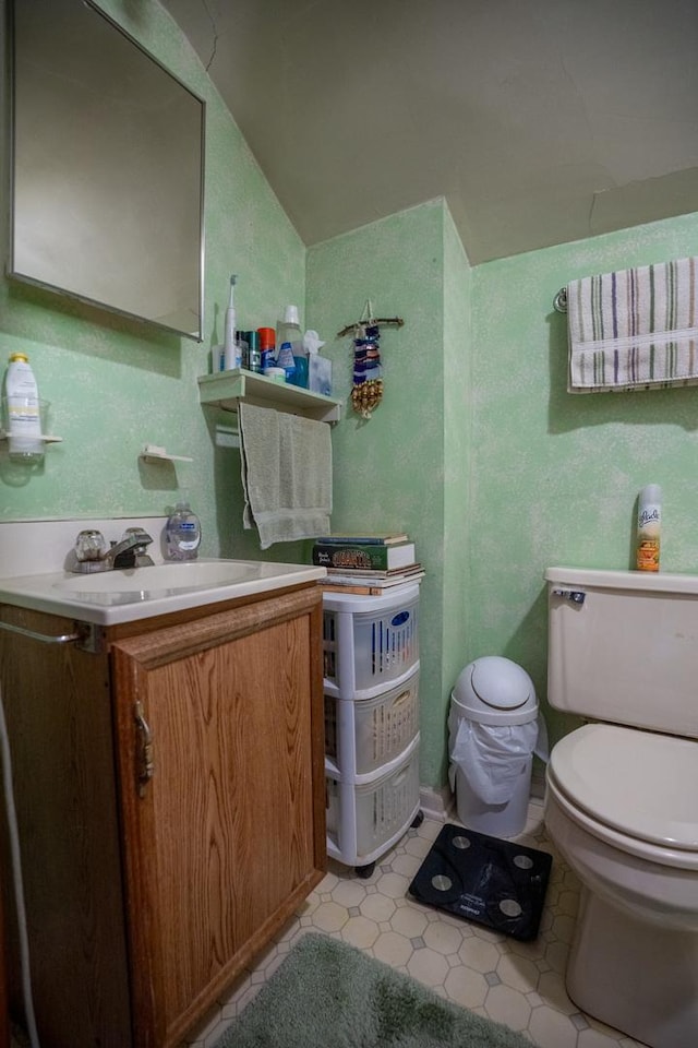 bathroom with toilet, lofted ceiling, and vanity