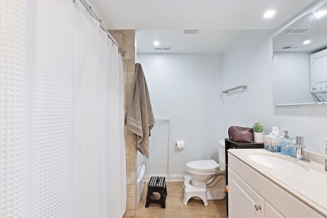 bathroom with tile flooring, toilet, and large vanity