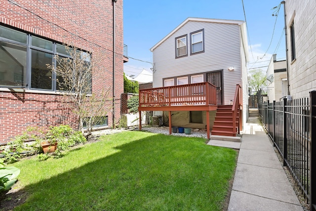 back of property with a deck, central air condition unit, and a lawn