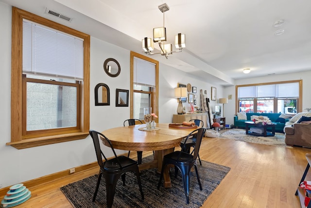 dining room with hardwood / wood-style floors and a chandelier