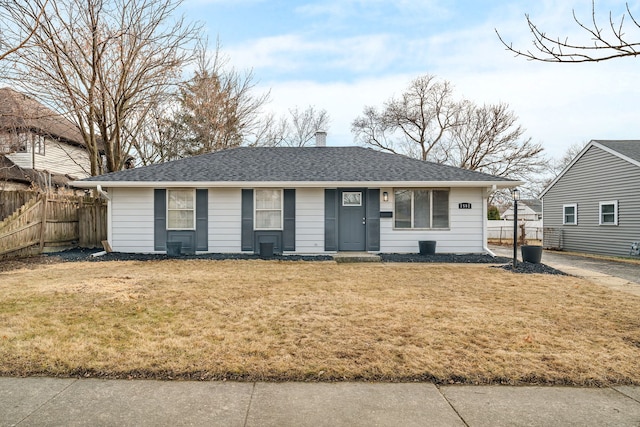 ranch-style house with a front lawn, a chimney, a shingled roof, and fence