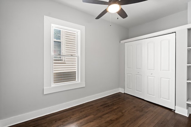 unfurnished bedroom with a closet, dark wood-type flooring, and ceiling fan