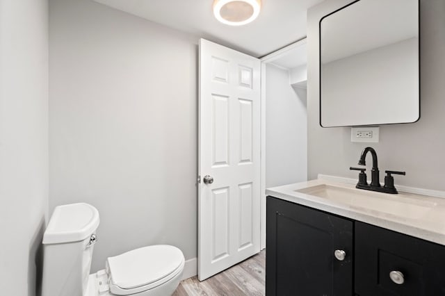 bathroom featuring wood-type flooring, vanity, and toilet