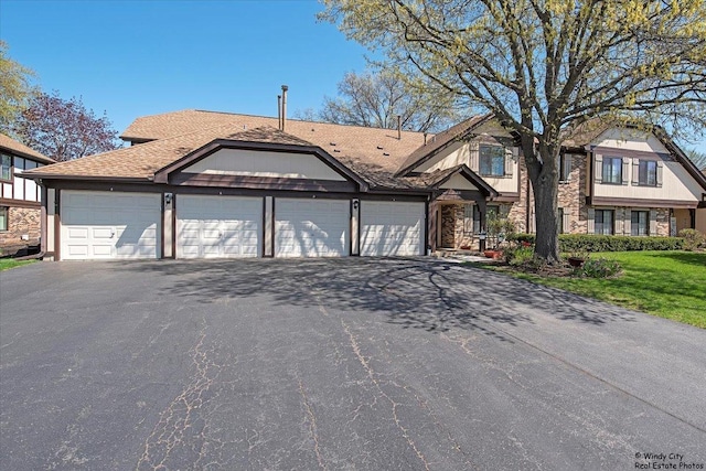 view of front of property featuring roof with shingles, driveway, stone siding, and a garage