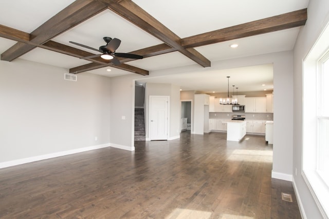 unfurnished living room with beamed ceiling, dark hardwood / wood-style flooring, coffered ceiling, and ceiling fan with notable chandelier