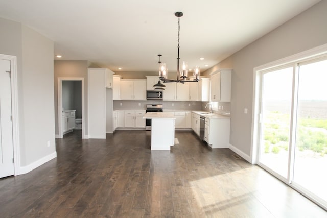 kitchen featuring dark wood-type flooring, a wealth of natural light, pendant lighting, and appliances with stainless steel finishes