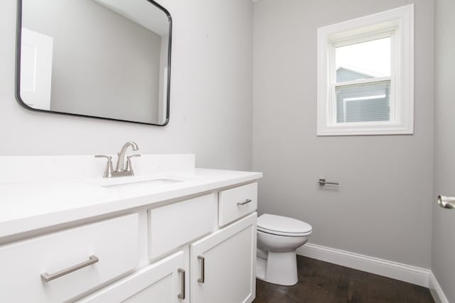 bathroom featuring hardwood / wood-style flooring, toilet, and vanity