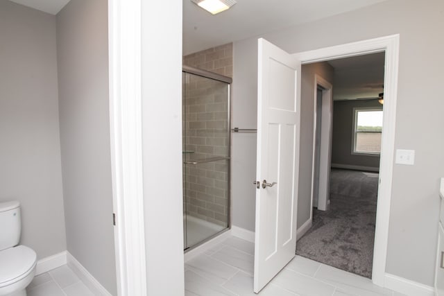 bathroom with a shower with shower door, tile flooring, and toilet