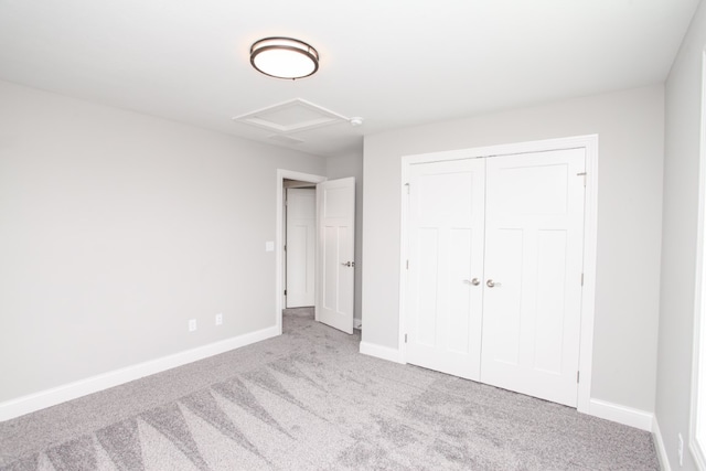 unfurnished bedroom with light carpet and a closet