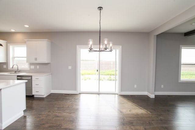 unfurnished dining area featuring a notable chandelier, sink, and dark hardwood / wood-style flooring