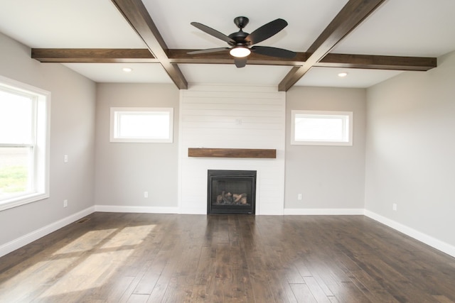 unfurnished living room featuring beam ceiling, a wealth of natural light, and dark hardwood / wood-style flooring