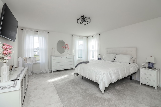 bedroom with multiple windows and light colored carpet