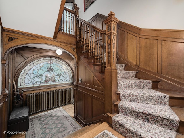 stairway featuring a high ceiling and radiator