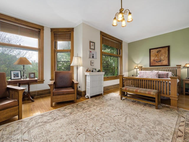 bedroom featuring ornamental molding, a notable chandelier, radiator heating unit, and hardwood / wood-style flooring