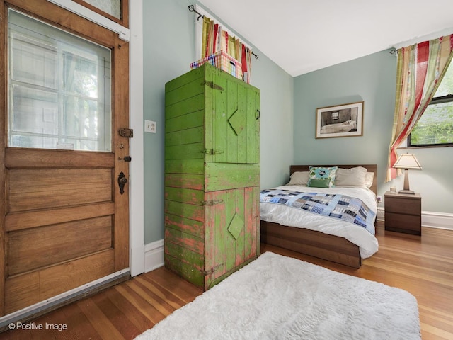 bedroom with baseboards and wood finished floors