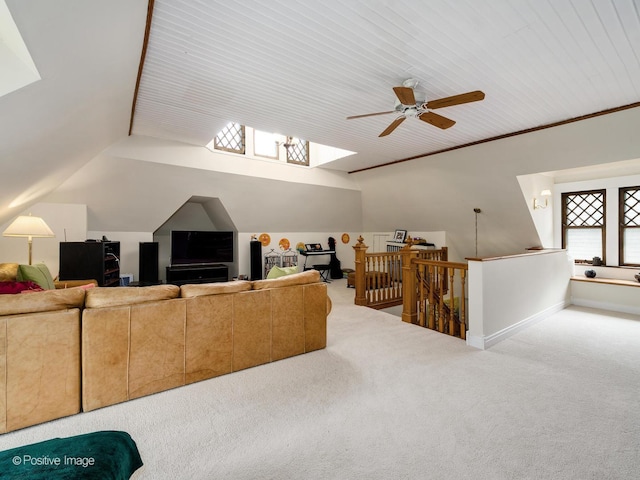 living area featuring vaulted ceiling, baseboards, carpet flooring, and crown molding