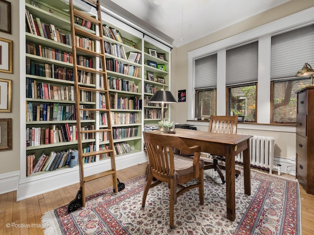 office space with hardwood / wood-style flooring and radiator heating unit