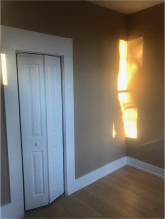 unfurnished bedroom featuring dark wood-type flooring and a closet