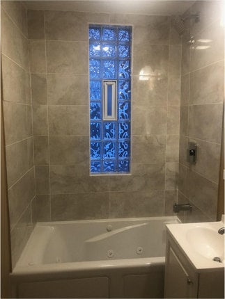 bathroom featuring vanity and tiled shower / bath