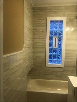 bathroom featuring vanity, tile walls, and bathing tub / shower combination