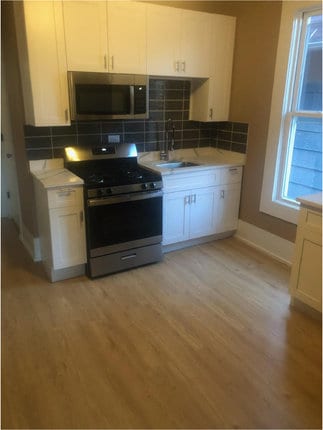 kitchen with light hardwood / wood-style flooring, white cabinets, stainless steel appliances, and sink