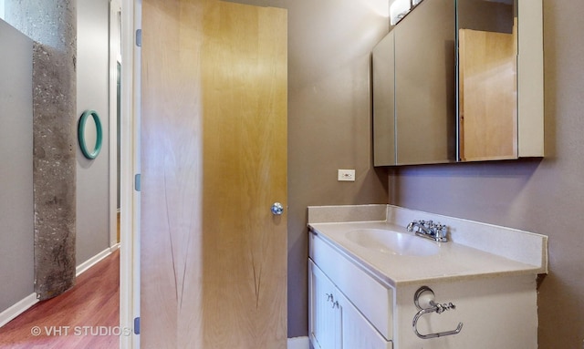 bathroom with vanity, baseboards, and wood finished floors