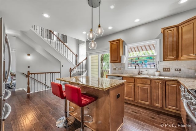 kitchen with dark hardwood / wood-style flooring, backsplash, sink, and a kitchen island