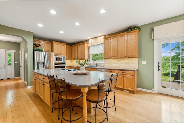 kitchen with appliances with stainless steel finishes, a sink, baseboards, backsplash, and recessed lighting