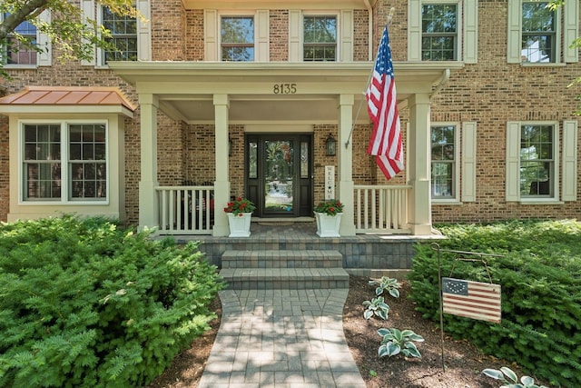property entrance featuring brick siding and covered porch