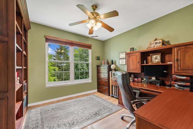 office featuring light wood-style flooring, ceiling fan, and baseboards