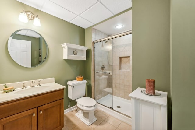 bathroom featuring a shower stall, tile patterned flooring, toilet, vanity, and baseboards