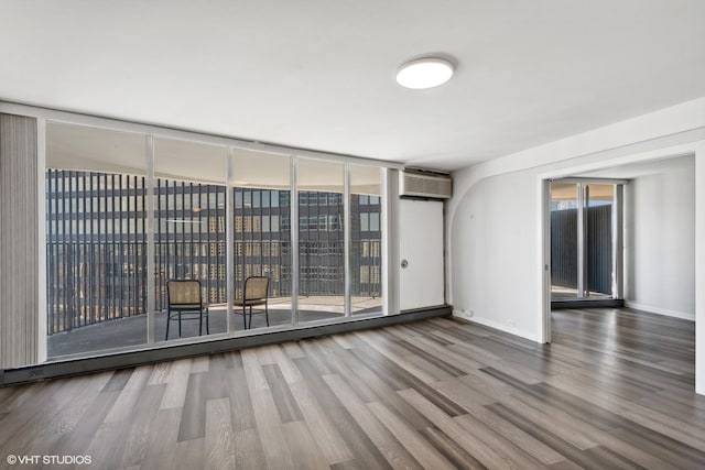 empty room featuring dark hardwood / wood-style floors and a wall mounted AC