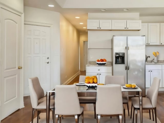 kitchen with white cabinetry, stainless steel fridge with ice dispenser, and hardwood / wood-style flooring