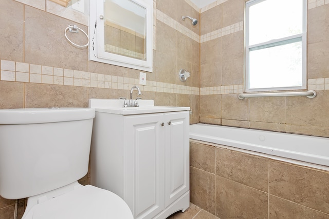 full bathroom with toilet, tiled shower / bath combo, vanity, and tile walls